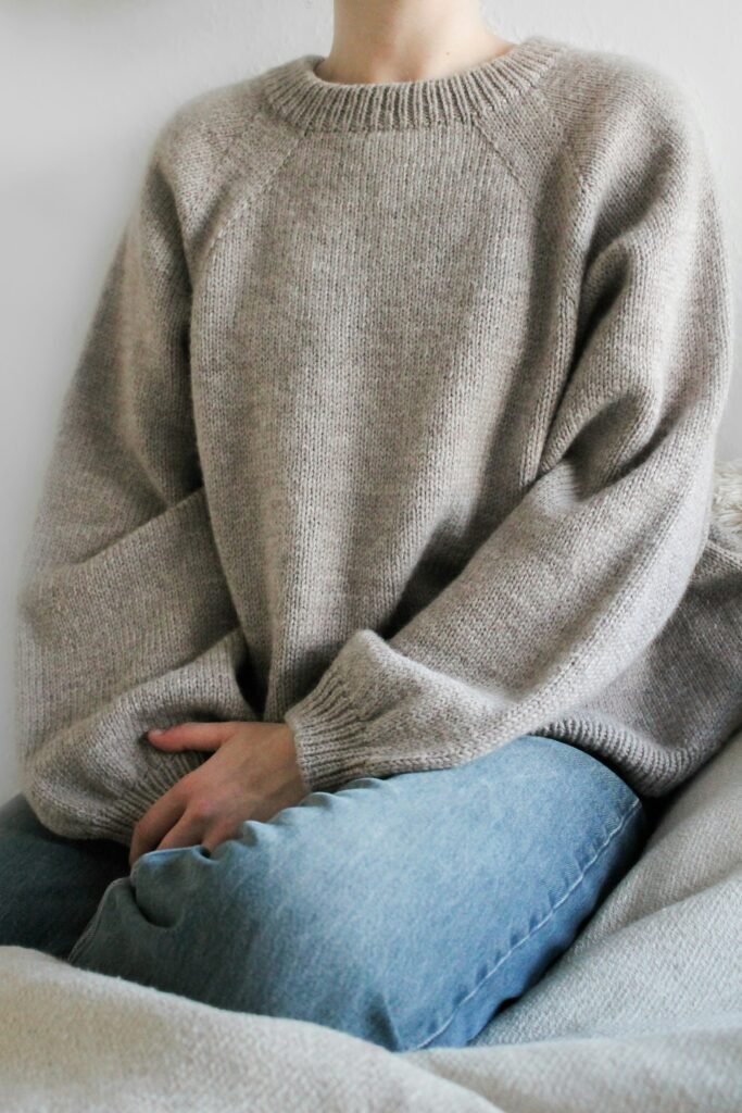 Cropped photo of a person wearing a grey knit sweater