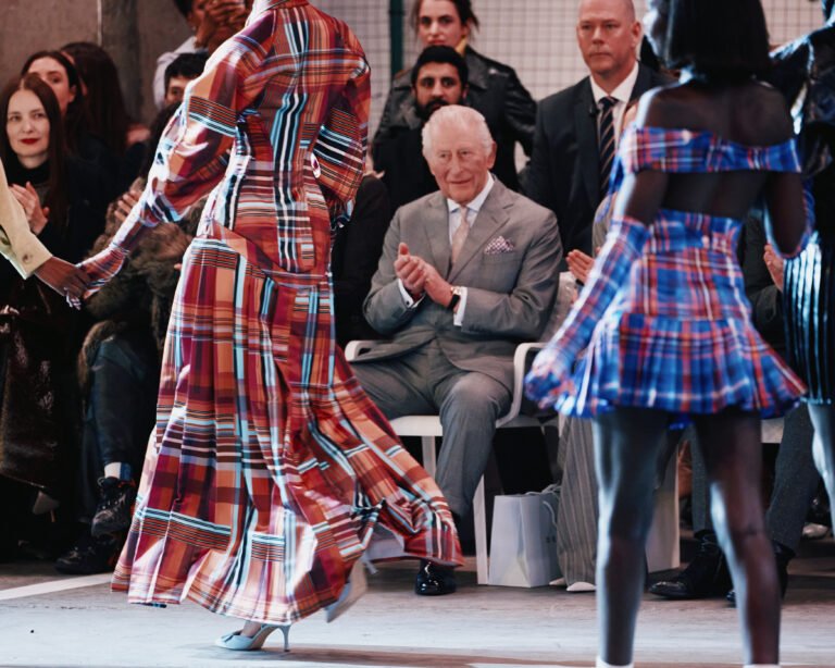 King Charles III sits in the front row as models walk the runway in plaid looks during Tolu Coker at London Fashion Week (February 2026).