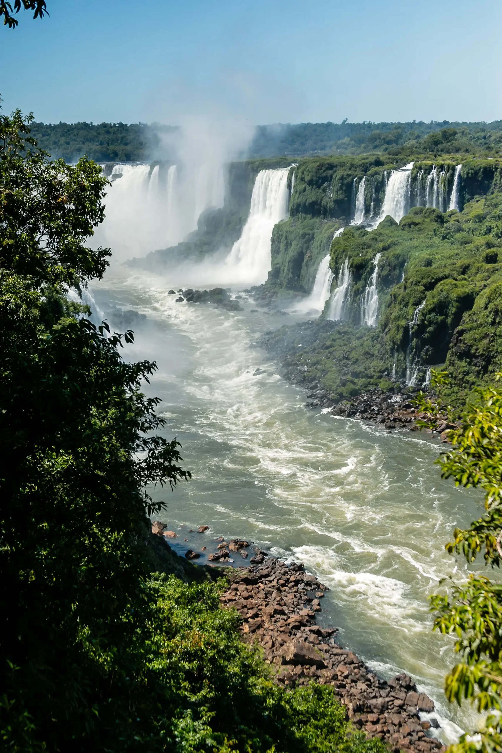 Panoramic view of Iguazu Falls framed by the Atlantic Forest in Foz do Iguaçu, Brazil.